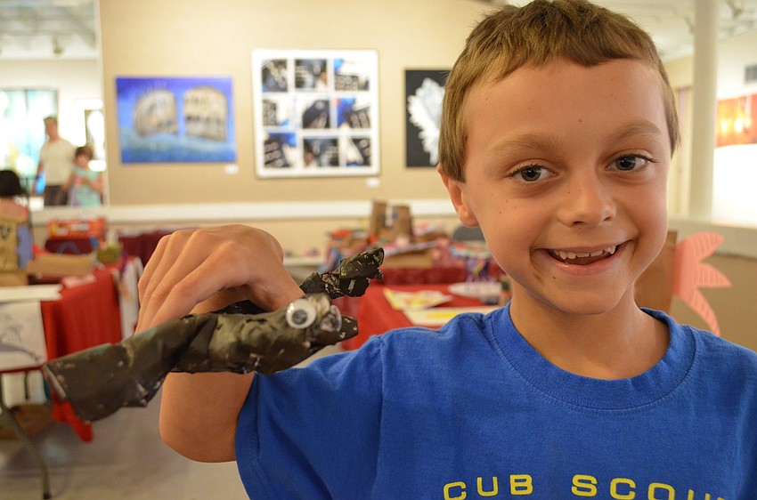 Austin Bruce shows off his paper mache dragon