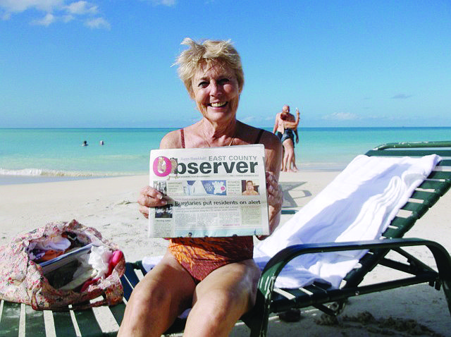 LIFE'S A BEACH. Lakewood Ranch resident Darlene Stewart catches up on her East County news while catching some rays in Brazil.