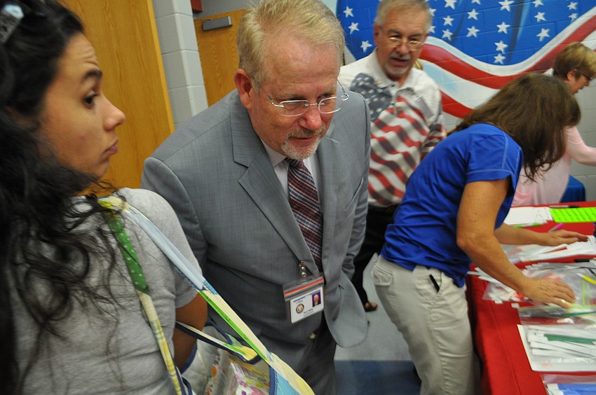 Superintendent Rick Mills leans in to talk with a student at Freedom Elementary.