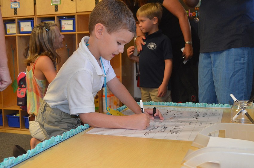 Seb B. signs in to his first day of kindergarten.
