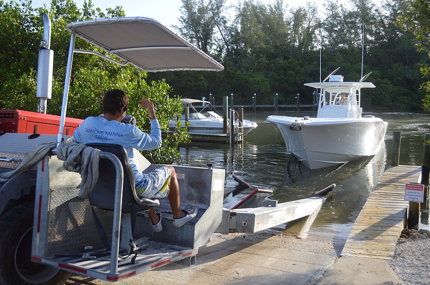 Cannons Marina Support Capt. Corey Gropp signals in a boat to pull it out of the water for cleaning. Cannons has operated on Longboat Key for nearly 60 years and is the oldest town business under the same ownership.