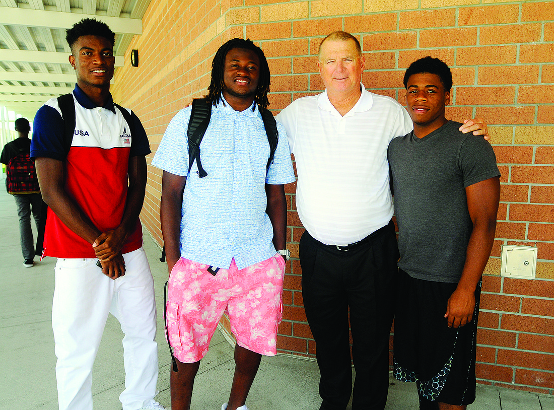 Bob Bowling, pictured with football players Justin Ross, Jimiah Albritton and Davion Banks, is the only athletic director Braden River High has ever known since it opened its doors in 2005. Photo by Jen Blanco