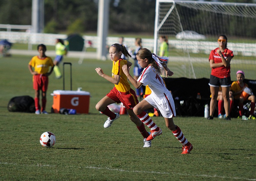Ten-year-old Nicole Sakre, left, battles a West Pasco Black defender for possession.