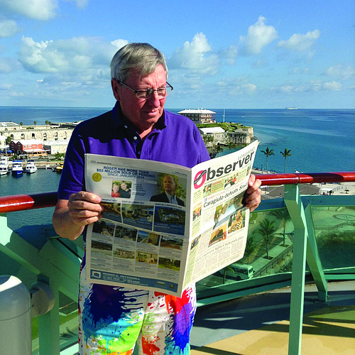 WILD TIME. Longboat resident John Wild stays on top of the latest news while in Hamilton, Bermuda.