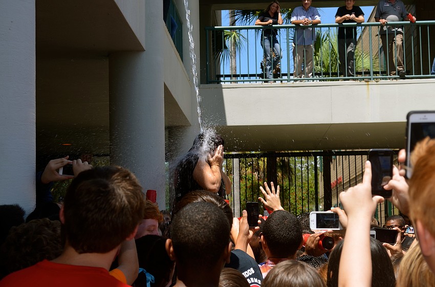 Faculty member Michele McClellan gets soaked by cold water.