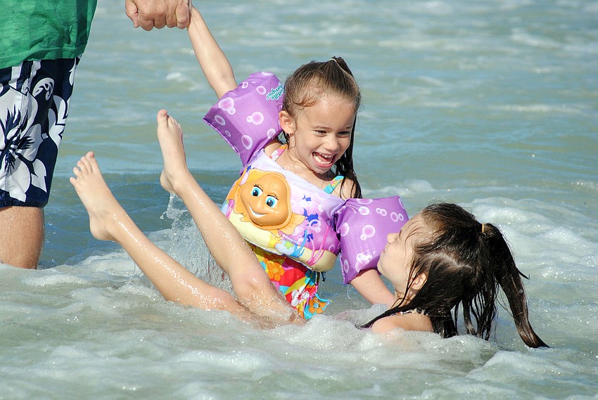 Sisters Juliet and Jessie Cantrell play in the water.