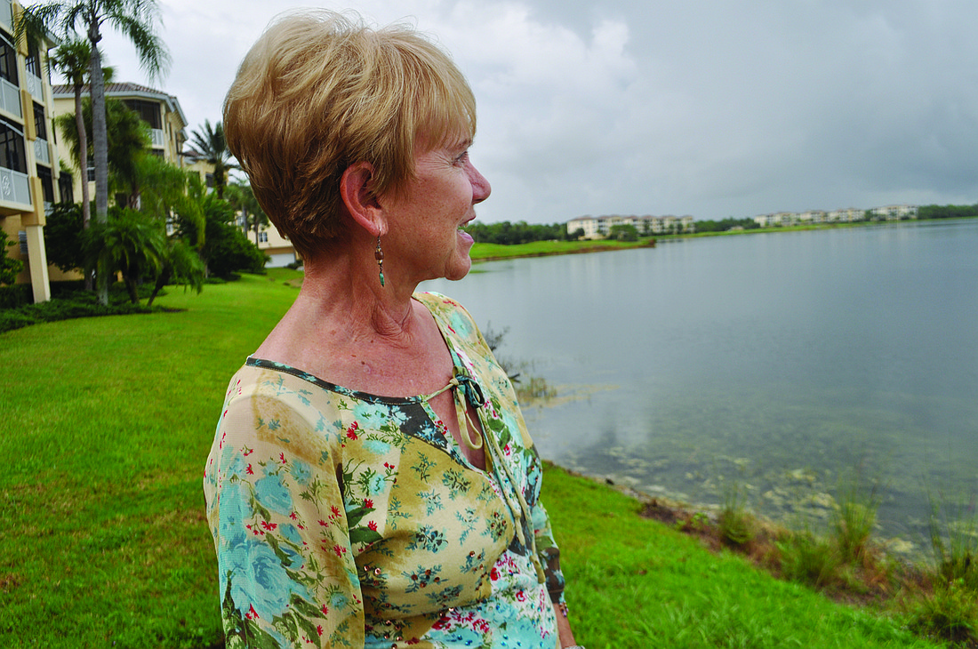 Connie McKenzie looks across Lake Uihlein from the ground level of her building 1 Watercrest condominium complex. Photo by Pam Eubanks
