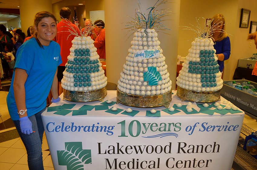 Event volunteer Brooke Cutchen gives samples of the hospital's 10-year anniversary cake.