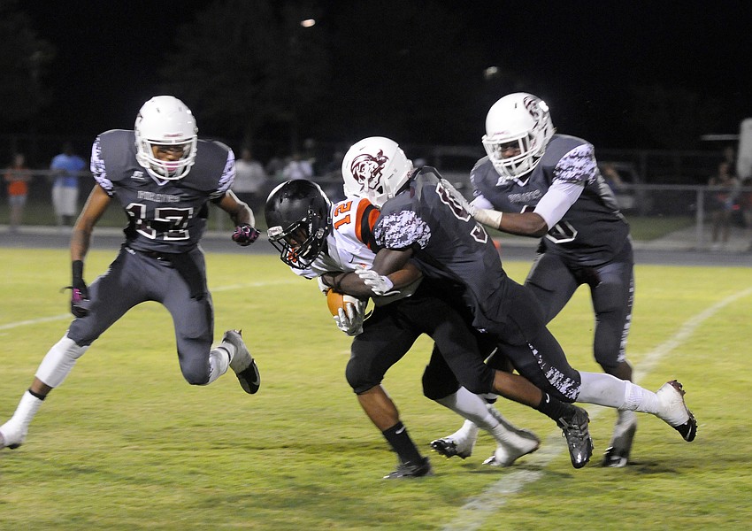 Braden River defenders Demetrius Lawson, JoJo Louis and Jimiah Albritton tackle Sarasota wide receiver Dakota Cotner in the first half.