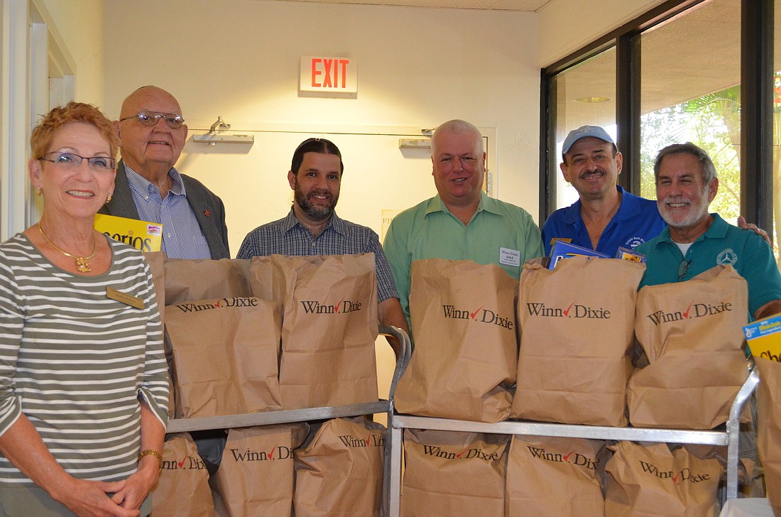 Molly Ballow, William Fogel, Rabbi Michael Werbow, Dale Root, Joel Servetz an Ben Berman stand with the 170 bags of donated food.