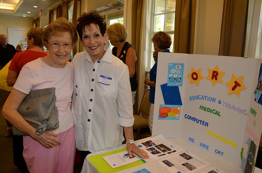 Joanne Cassandra receives club information from Natalie Abrams.
