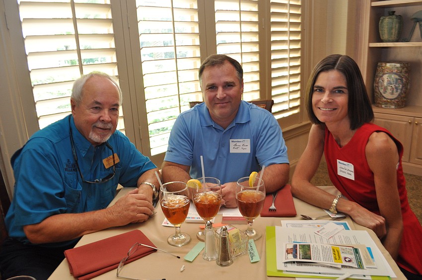 Richard Curtis, of Keller Williams, talks with Aaron Kerr, of Fast Signs, and Jennifer Stevens, of Stretch Zone.