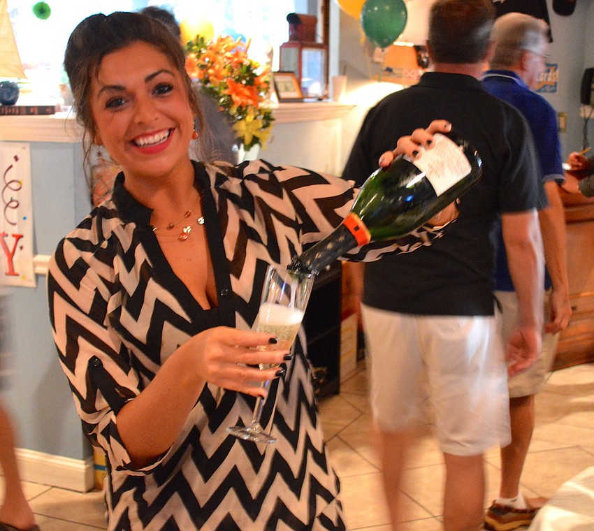 Courtney Rossler pours Champagne for guests as they enter.