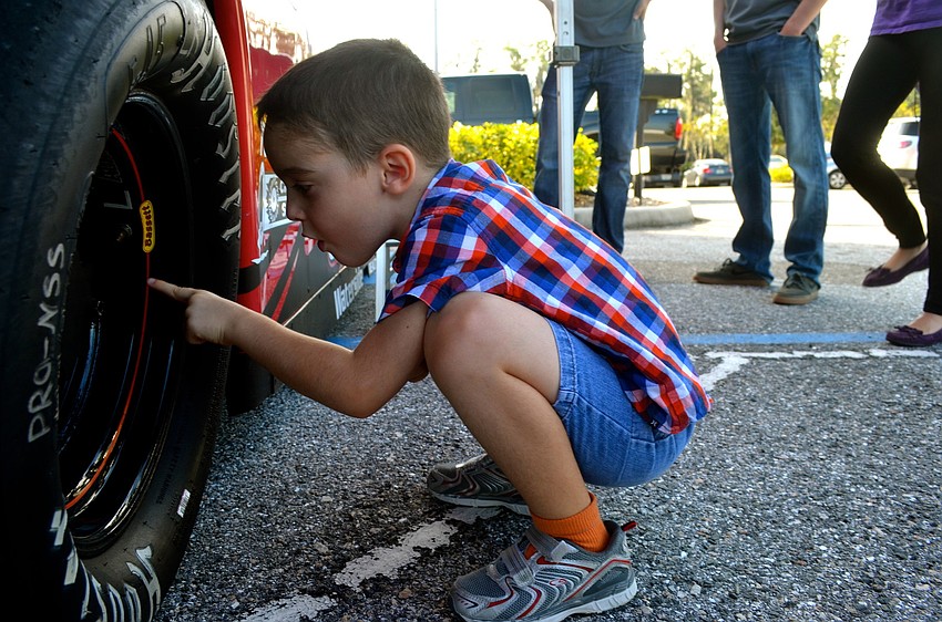 Colin Robinson inspects a race car tire.