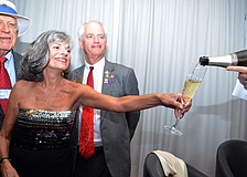 President of the Rotary Club, Sydelle Pittas, gets a refill of champagne at the club's first official charter meeting.
