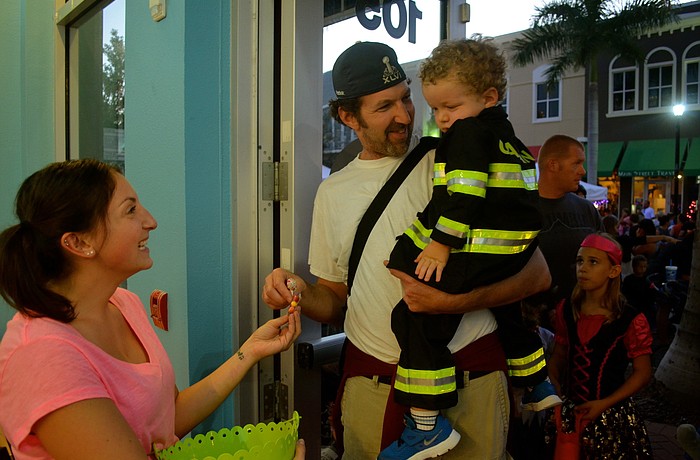Kelly Sobrito gives candy to Craig Goldstein and his and firefighter son, Gabe.