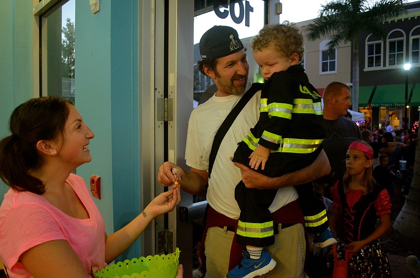 Kelly Sobrito gives candy to Craig Goldstein and his and firefighter son, Gabe.