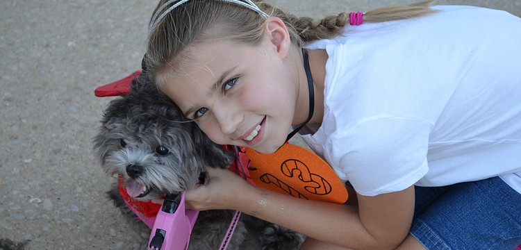 Madelyn Stevens poses with her â€œlittle devilâ€ Lola at the Stonebrook Halloween Doggie Parade.