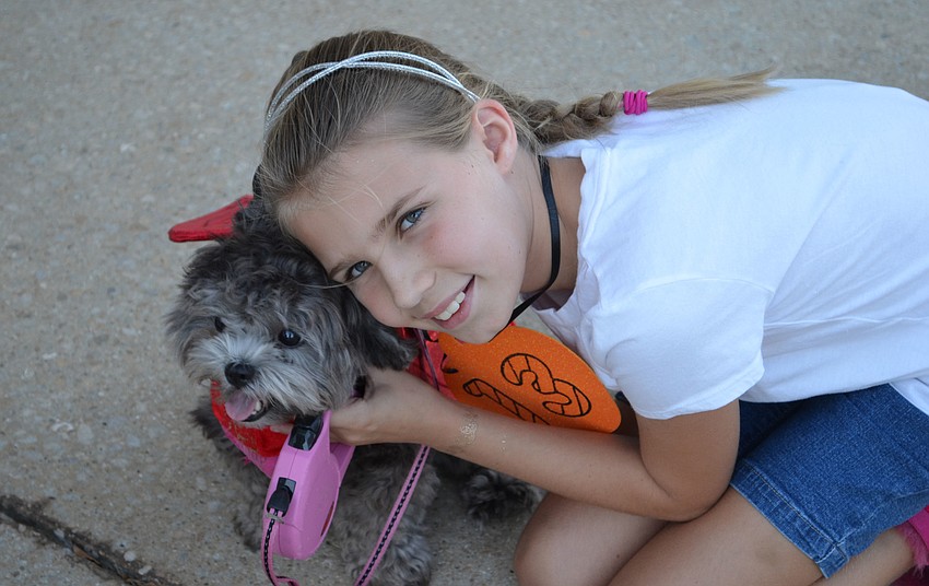 Madelyn Stevens poses with her â€œlittle devilâ€ Lola at the Stonebrook Halloween Doggie Parade.