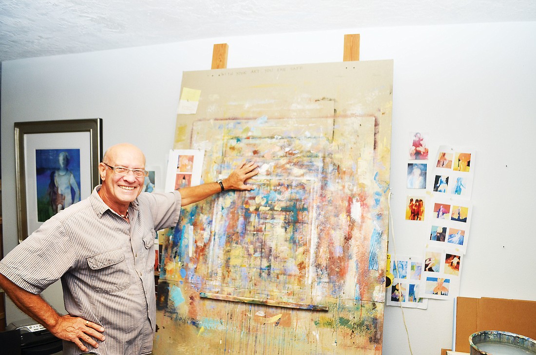 Larry Forgard stands at the door into his art: his tall, paint-splattered easel.