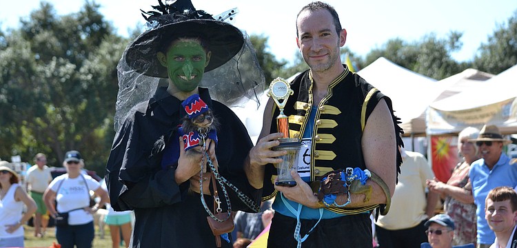 Alex Breslin dressed as the Wicked Witch of the West from the Wizard of Oz, holds Java Chip who is dressed as a flying monkey. Dan Plonsky is dressed as a flying monkey as well and is holding Danny, a squirrel monkey.