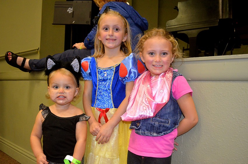 Sisters Julianne, Reagan and Shannon Mathews play dress up.