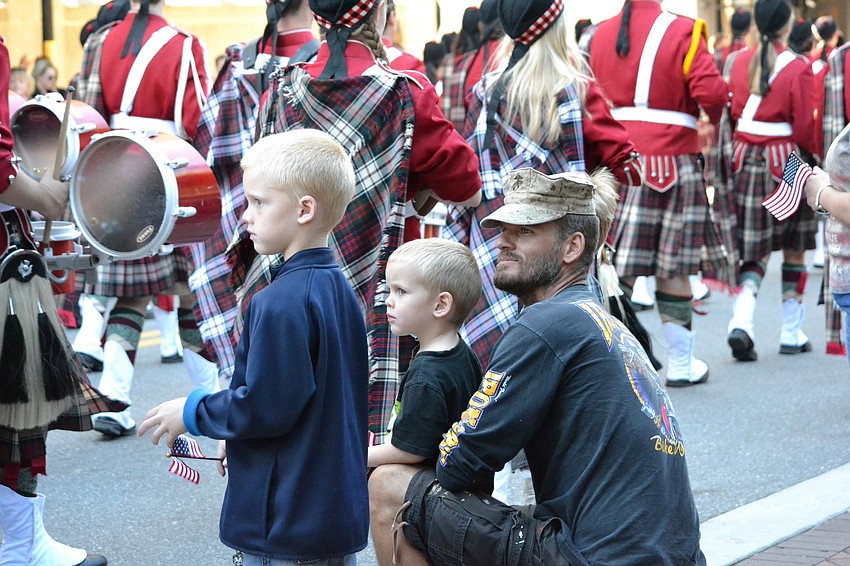 Veteran Shane Burggraff watches the Veterans Day Parade with his son Kyle and Joel.