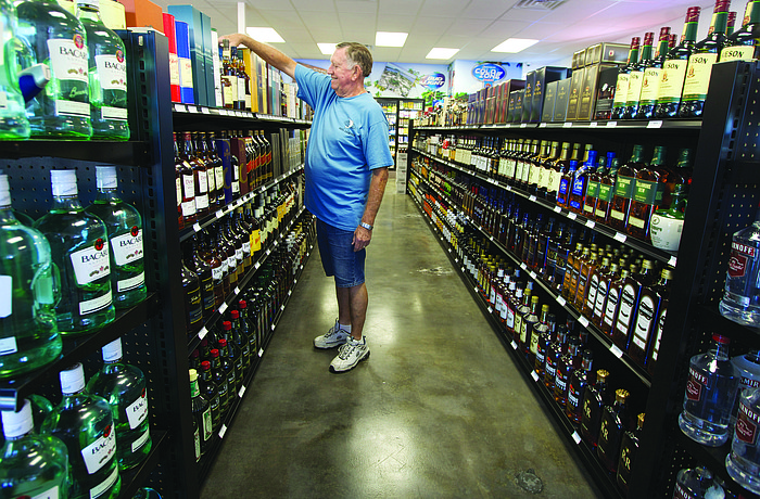 Jim Crawford helps stock whiskey and other liquors.File photo