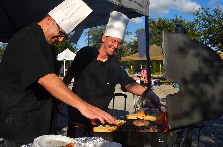 Phil Brannon and Harris Bash, of The Pig Mac, flip burgers for guests.