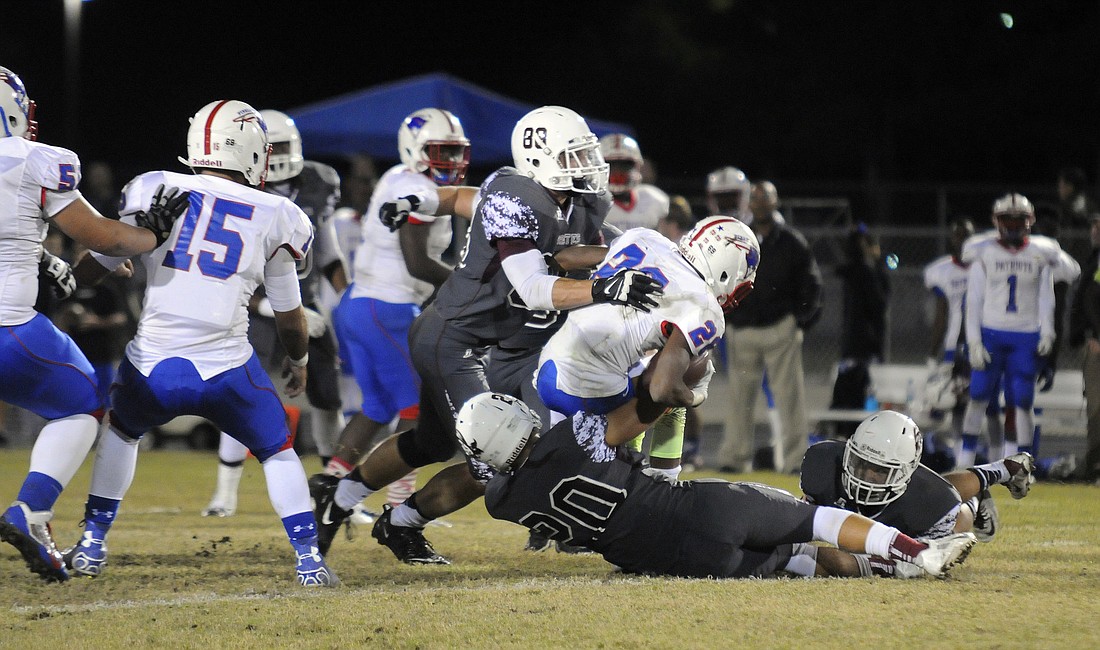 Braden River defenders Derek Hintze and Chase Balliette tackle Pinellas Park running back Marcelus Ware for no gain. Photos by Jen Blanco