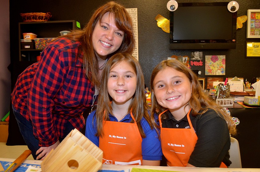 Nicole Lopez and her daughter, Mikayla, work with Emma Wadle to put together the birdhouses.