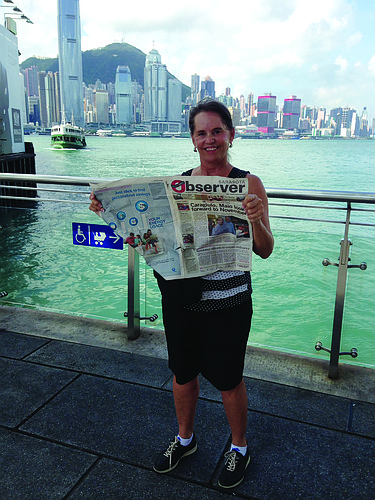 TOUR GUIDE. Mary Puleo peruses the Observer while awaiting a tour boat ride in the Hong Kong harbor.