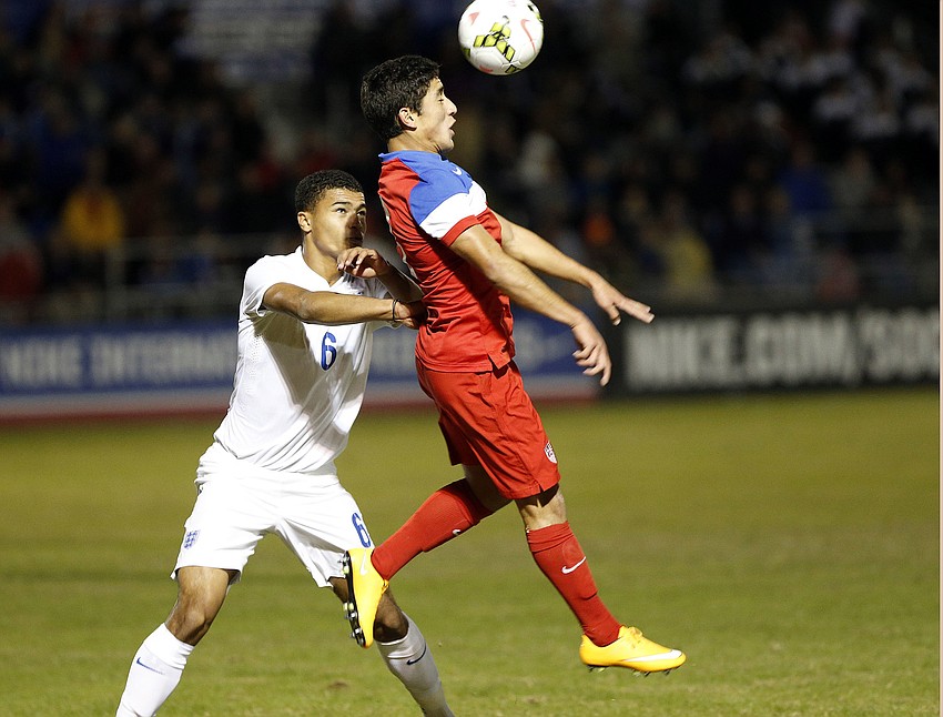 U.S. forward Josh Perez heads the ball away from Englandâ€™s Cameron Humphreys.