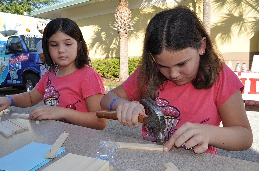Â Best friends Reagan Baker and Ariel Schreiber make pencil holders at a booth by Home Depot.