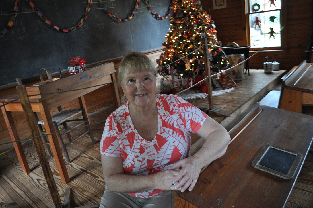 Sandy Stanford, of The Inlets, decorates each building on the Manatee Village property with extra care. Here, sheÃ¢â‚¬â„¢s pictured in the schoolhouse she decorated with paper gingerbread men cutouts in the windows and paper chains along the chalkboard.