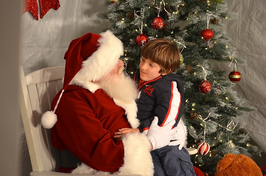 Santa listens to Carter Ebling's Christmas list.