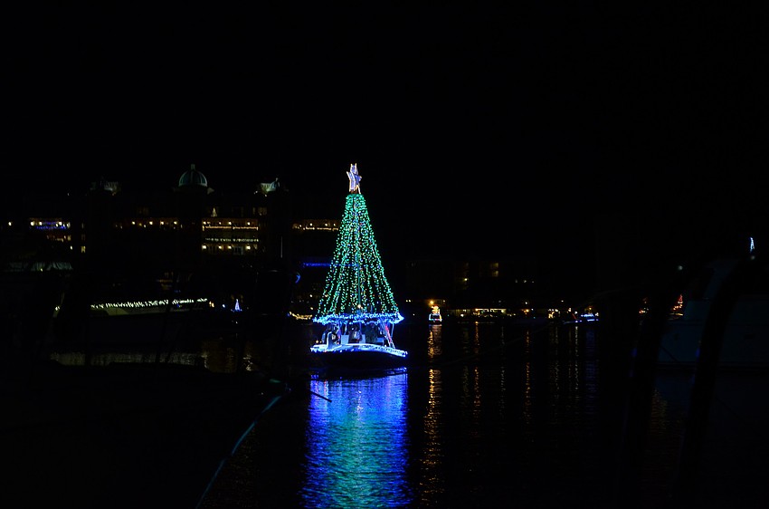 A boat decorated as a Christmas tree makes its way down the bay for the Holiday Boat Parade of Lights.