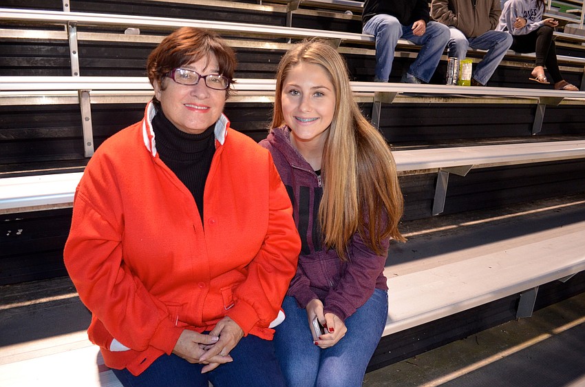 Carolyn Tharpe and Kendall Wilson stay warm during the game.
