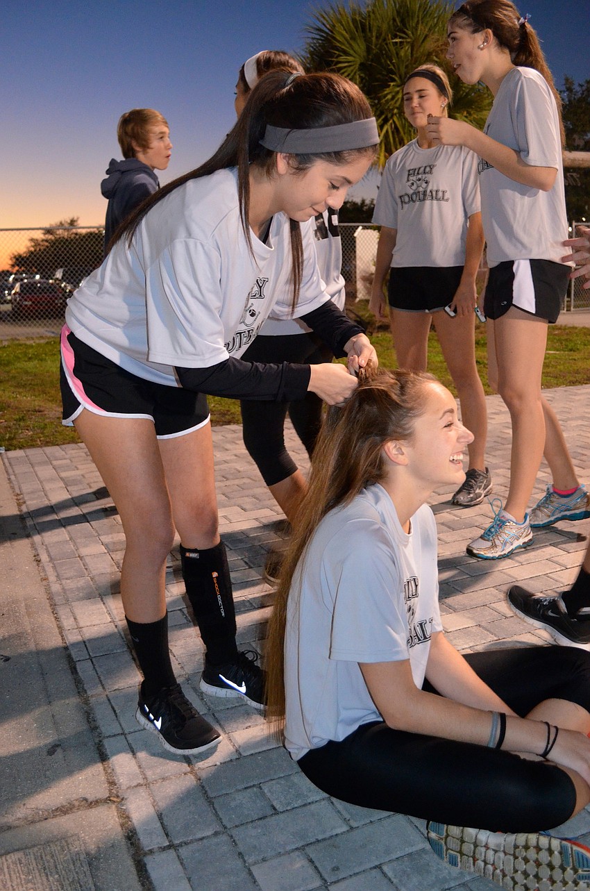 Stephanie Cisneros helps Candace Powell get ready for the game.