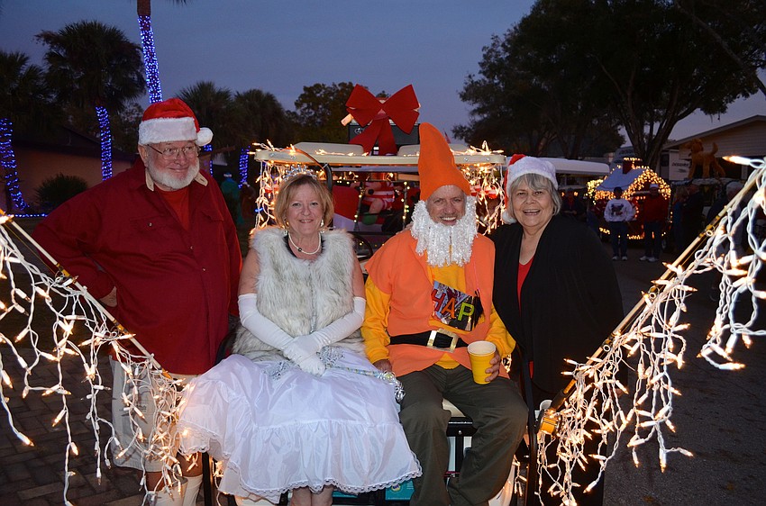Bud Smith, Louise and Michael Gravel and Linda Smith showcase a brightly-lit cart.