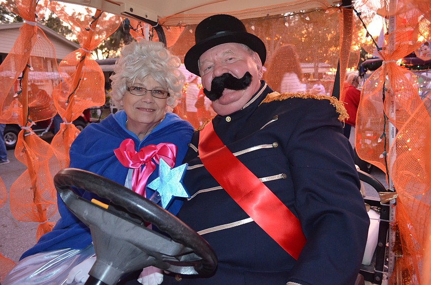 Diane and David Childs show off their costumes inside their pumpkin golf cart.