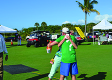 Holly Baran hugs Longboat Key Gourmet Lawn Party Chairman Michael Garey after winning the second prize of "A Year of Delicious Dining" in the event's raffle Dec. 6, at the Longboat Key Club's Islandside driving range.