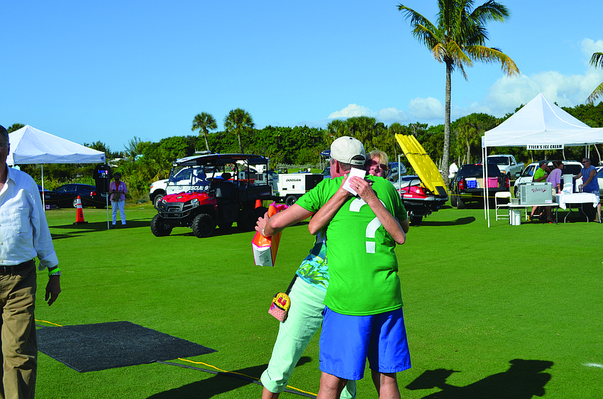 Holly Baran hugs Longboat Key Gourmet Lawn Party Chairman Michael Garey after winning the second prize of 