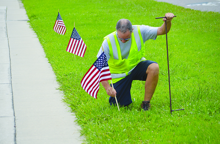Longboat Key Public Works Department crew leader Mark Kerr places one of 2,977 flags along Gulf of Mexico Drive in September â€” one in honor of each victim of the Sept. 11, 2001 terrorist attack.