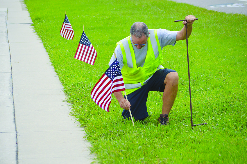 Longboat Key Public Works Department crew leader Mark Kerr places one of 2,977 flags along Gulf of Mexico Drive in September â€” one in honor of each victim of the Sept. 11, 2001 terrorist attack.