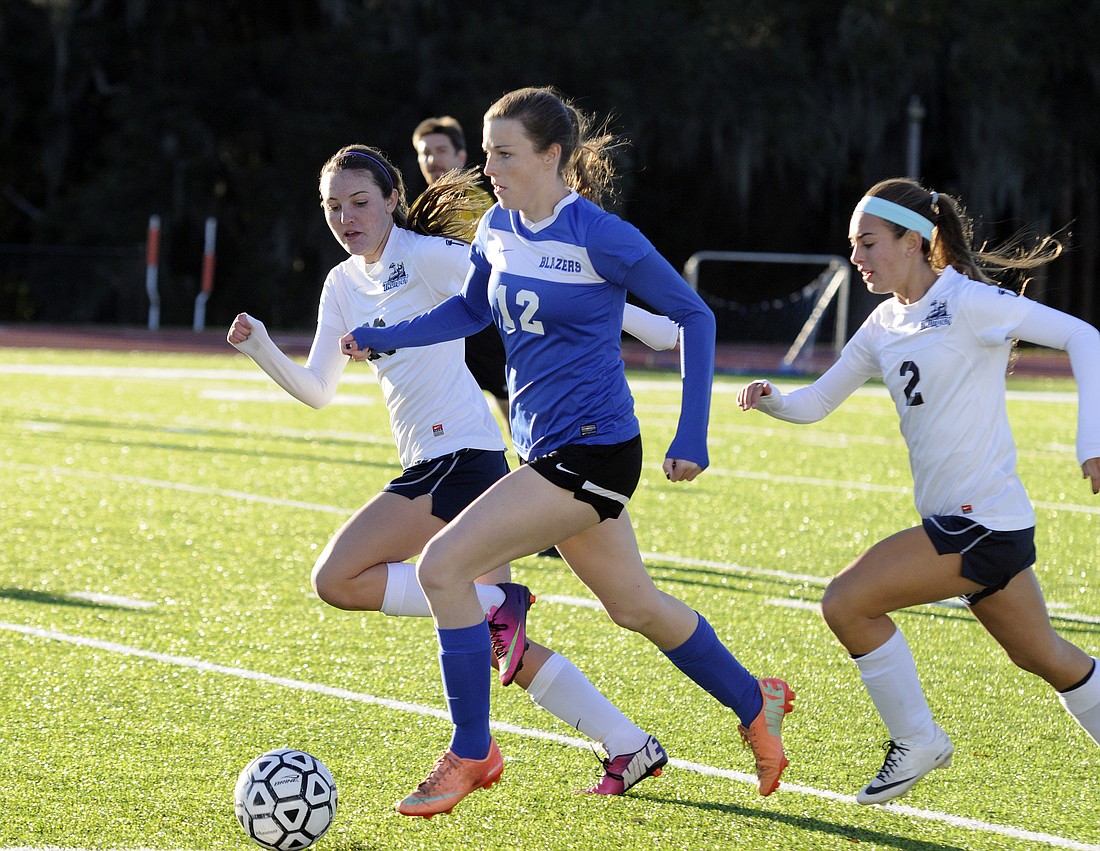 Sarasota Christian senior Kelsey Murphy dribbles the ball past a pair of the Out-of-Door Academy midfielders in a 1-0 semifinals win Jan. 16.