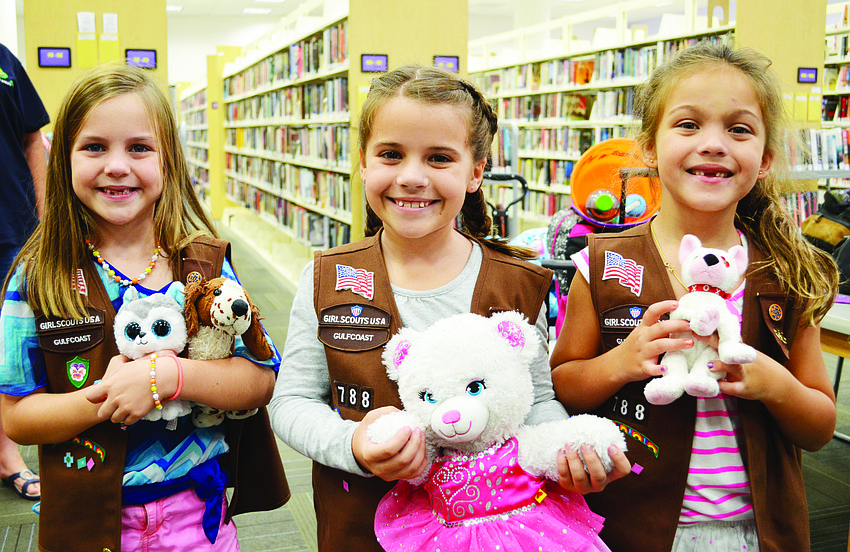 Girl Scouts Meredith Carroll, Abbi Geiger and Lilly Irelan hug their favorite stuffed animals at a sleepover at Selby Public Library.