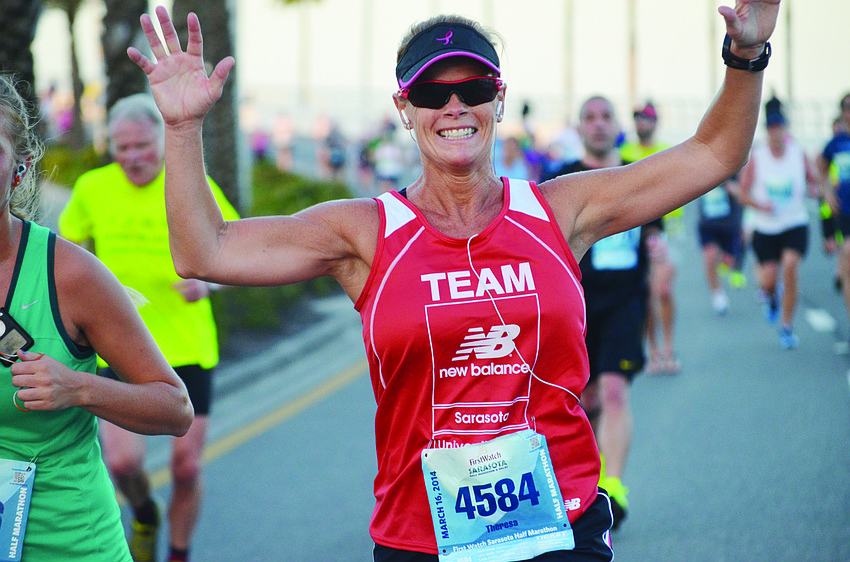 Theresa Young celebrates coming over the Ringling Bridge during the ninth annual Sarasota Half Marathon.