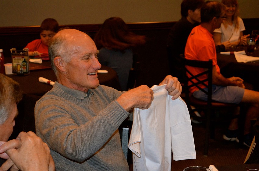 Ray Turner admires his shirt, which he received for running 500 miles last year.