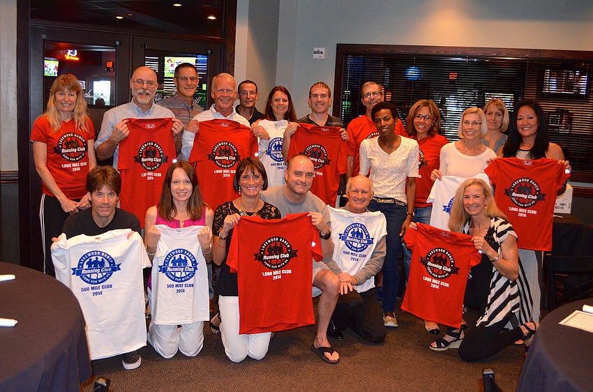 Club members who ran 500 or 1,000 miles last year show off their new shirts.